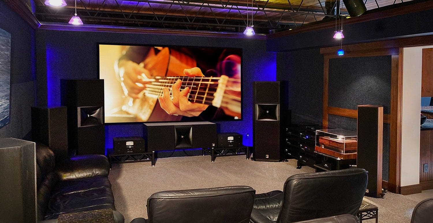 A room with a large screen and speakers