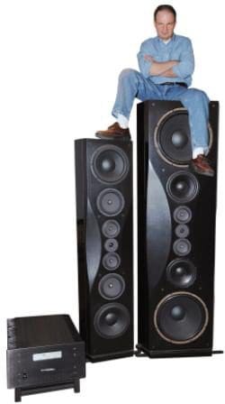 A man sitting on top of two large speakers.