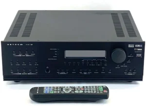 A remote control sitting next to an audio stereo receiver.