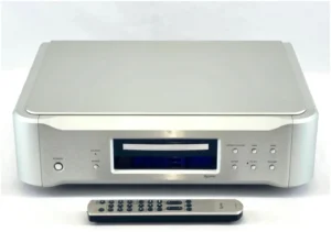 A silver dvd player with remote control on top of it.